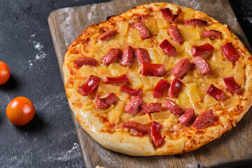 Homemade pizza with pineapple, sausage, tomato sauce and cheese. Simple country food.