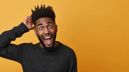 man with a beard and tousled hair is making a playful gesture to his head with his fingers, wearing a black turtleneck sweater with a joyful expression against a yellow background
