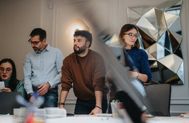 Diverse team of business professionals collaborating in modern office setting.