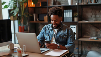 Fototapeta premium man with a beard, smiling and using a smartphone while seated in a wheelchair at a desk with a computer