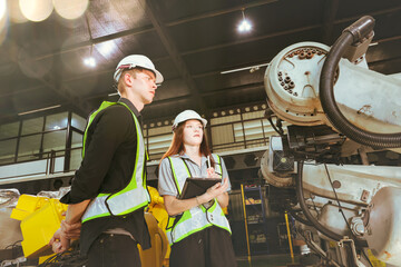 Male and female electricians check analog controls welding robot in testing process electrical...
