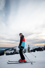 skier on a ski slope during a sunset with colorful sky
