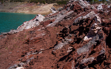 Fototapeta premium Red stones, blue sky, green water