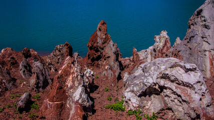 Red stones, blue sky, green water