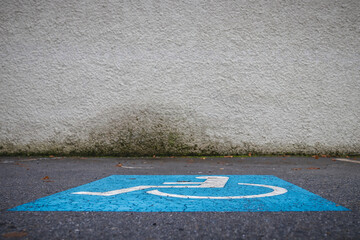 Disabled parking sign painted on the ground of a car park. Parking lot space for persons with...