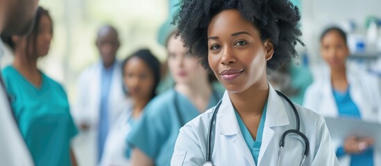 A group of healthcare professionals, including black individuals and nurses, are using digital technology to work together in a hospital. They are discussing medical research findings and test results - obrazy, fototapety, plakaty