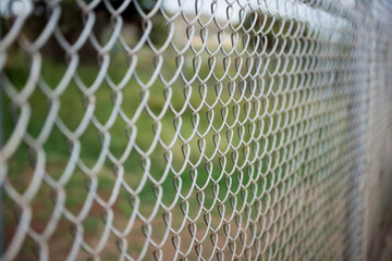 Fence with metal grid in perspective. Metal chain-link fence as the background, street photo, close-up,