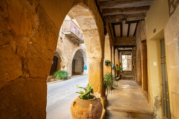 colonnade with arcades on a street with traditional old houses in the medieval town of Batea, comarca of Terra Alta, Province of Tarragona, Catalonia, Spain