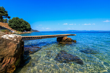 Fototapeta premium Beautiful scene from wooden pier and turquoise sea.Tarsanas Beach, Thassos, Greece