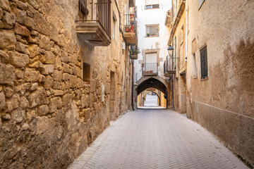 narrow street with traditional old houses in the medieval town of Batea, comarca of Terra Alta, Province of Tarragona, Catalonia, Spain - obrazy, fototapety, plakaty