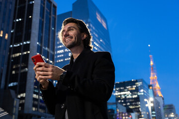View of young man using a smartphone at night