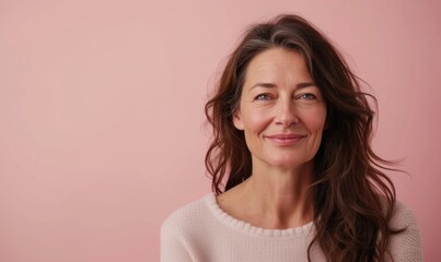 Fototapeta premium Portrait of a beautiful middle-aged woman on a pink background