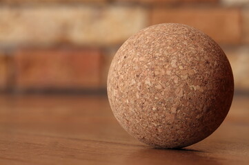 Ball made from wood processing waste on a brown background