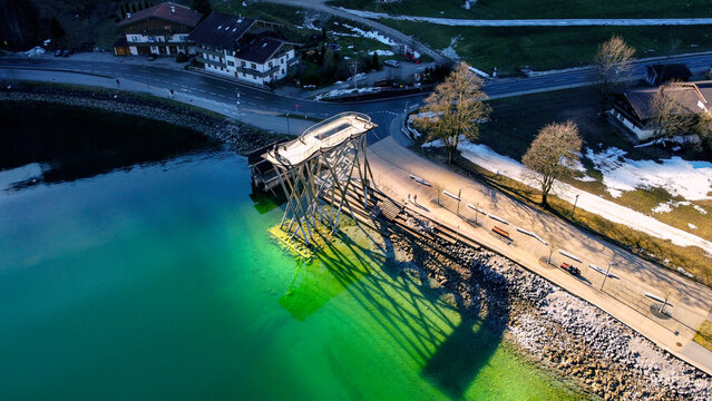 view of the lookout tower casting a shadow on the surface of Lake Achensee.