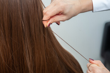 Photo of a European girl with long and beautiful brunette hair at the beauty salon. Shiny and...