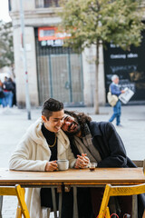 Happy gay couple in love enjoying a date outdoors in a cafe.