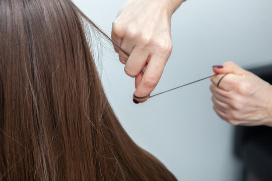 Photo of a European girl with long and beautiful brunette hair at the beauty salon. Shiny and healthy hair.