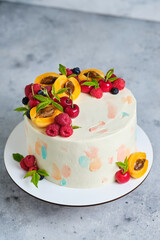 Delicious and beautiful handmade summer cake. Confectionery for the holiday. Dessert is decorated with fresh berries and fruits.