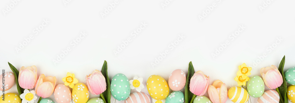 Poster easter eggs and flower decorations. top view bottom border against a white banner background. copy s