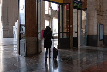 Tourist leaves Milan Central Station with his suitcase