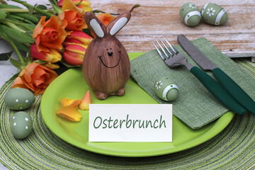 Tischdekoration Zum Osterfest: Teller, Besteck und Osterdekoration mit dem Text Osterbrunch auf...