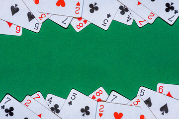 Playing cards on green felt casino table. Background with copy space in center