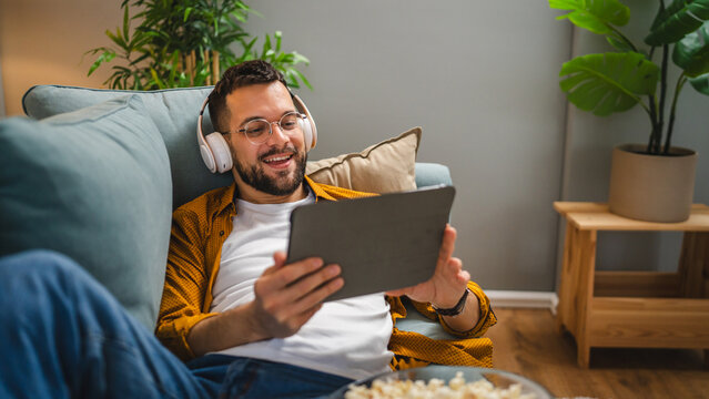 man sit on the sofa bed watch movie video online use digital tablet