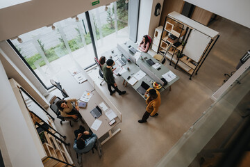 Overhead view of a contemporary office space with a diverse group of professionals engaging in work tasks.