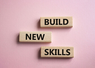 Build New skills symbol. Concept word Build New skills on wooden blocks. Beautiful pink background. Business and Build New skills concept. Copy space