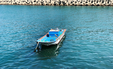 Naklejka premium A peaceful combination: a fishing boat against the sea and a stork hovering over the water. The photo conveys calmness and harmony between man and nature in the marine world