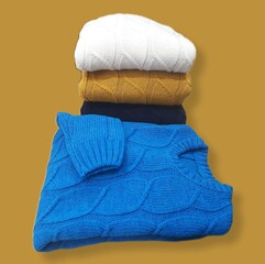 Stack of colorful wool sweaters on isolated background