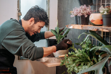 Young man smiles in plant store..concept: small plant and nursery business.