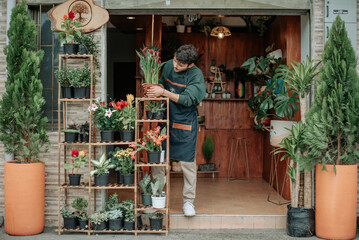 Young man smiles in plant store..concept: small plant and nursery business.