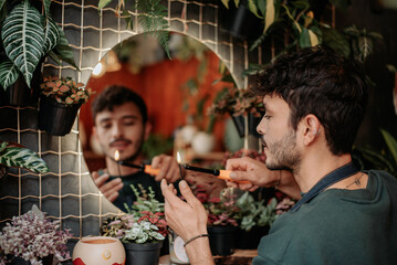 Young man smiles in plant store..concept: small plant and nursery business.