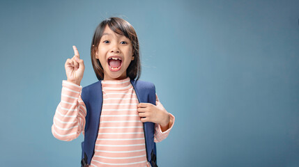A little girl is carrying a school bag and has an idea.
