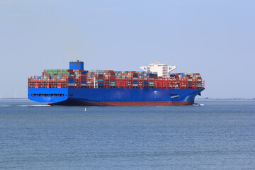 a big container ship navigates in the westerschelde sea towards the port of antwerp closeup