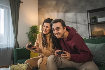 Foto op Canvas couple man and woman husband wife play console video games at home © Miljan Živković