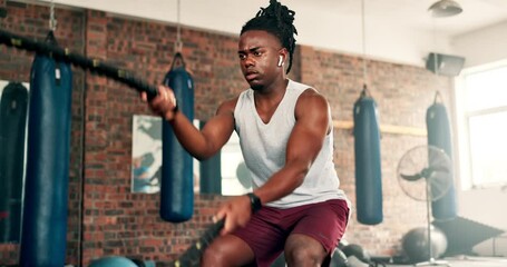 Fitness, battle ropes or black man training in gym for workout or wellness with resilience or power. Hard work, energy or healthy African sports athlete in exercise for biceps muscle or development