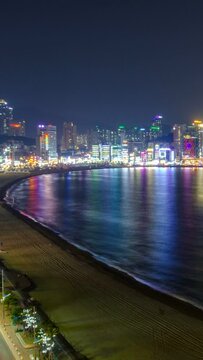 Gwangalli Beach in Busan night timelapse, South Korea. Aerial view. Zoom out effect