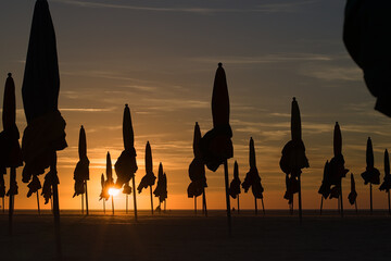 against the light of a parasol on the beach of Deauville in Normandy at sunset