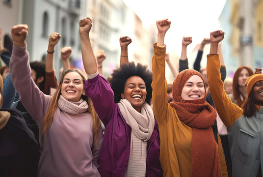 Multicultural group of women raising fists for International Womens Day. March 8 for feminism, independence, freedom, empowerment, and activism for women rights