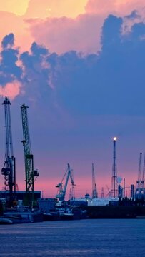 Port of Antwerp crane silhouettes in dusk twilight. Antwerp, Belgium. Camera pan