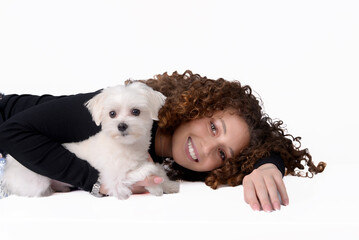 Girl with curly hair with a Maltese dog on a white background