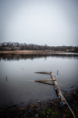 Mystery lake and forest in autumn colors . Lake in frost . Red colors . Fall on lake . House and buildings on the beach . Fishing house on the lake 