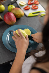 kitchen tasks, peeling a mango to prepare fruit salad, appetizing healthy food, housework and food, kitchen utensil