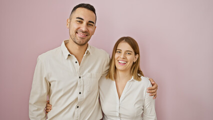 Happy couple embracing against a pink background exuding love and togetherness in a casual setting