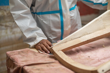 work table with a wooden chair and a person wearing overalls, workplace within a carpentry shop, objects and occupation, lifestyle