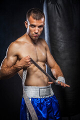 Fototapeta na wymiar Male boxer wrapping hand with bandage
