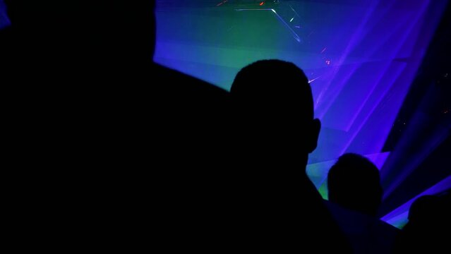 silhouettes of person and laser rays in disco