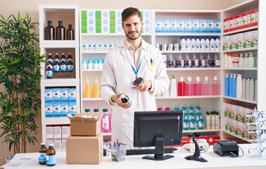 Young caucasian man pharmacist scanning medication bottle at pharmacy